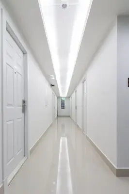 an empty corridor in a building with white doors at Peaberry Place - พีเบอร์รี่เพลส in Ban Zong Katiam