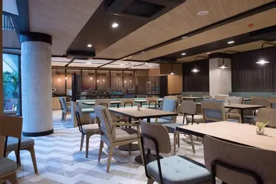 a restaurant with wooden tables and chairs and tables and chairs at Bella B Hotel in Nonthaburi