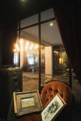 a room with two framed pictures and a chair at Baan Tuk Din Hotel in Bangkok