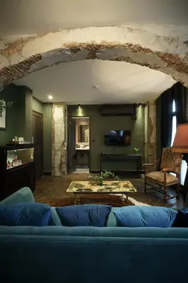 a living room with a blue couch and a table at Baan Tuk Din Hotel in Bangkok