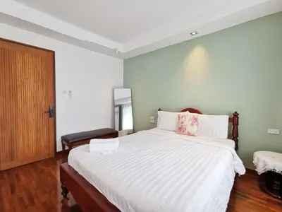 a bedroom with a large bed with white sheets at Sri Ayuttaya Guesthouse in Bangkok