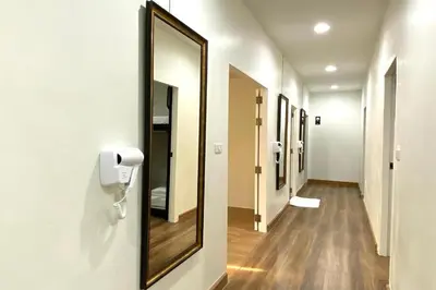 a hallway with a mirror and a phone on a wall at Forgotten Hostel Silom in Bang Rak