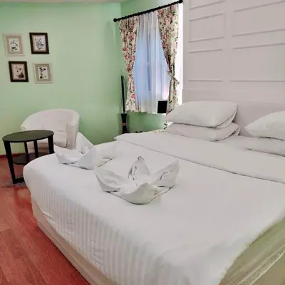 two white beds in a room with a window at Sabai Dee Minitel in Dusit