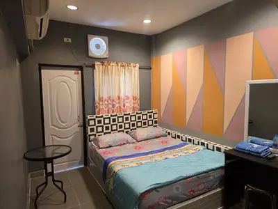 a small bedroom with a bed and a table at BEN HOUSE in Bangkok