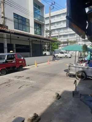 a parking lot with a food cart in front of a building at BEN HOUSE in Bangkok