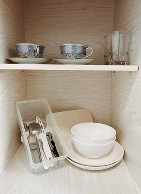 a shelf with plates and bowls and a tray with utensils at 32Sqm 1000x500wifi workplace long stay in Amphoe Phra Khanong