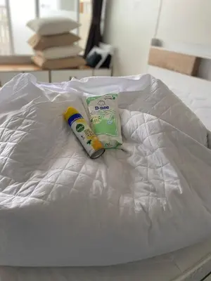 a tube of toothpaste and a bag on a bed at 32Sqm 1000x500wifi workplace long stay in Amphoe Phra Khanong