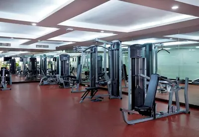 a gym with a lot of treadmills and machines at S.M. GRANDE RESIDENCE in Bangkok