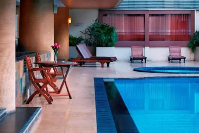 a patio with a table and a swimming pool at S.M. GRANDE RESIDENCE in Bangkok