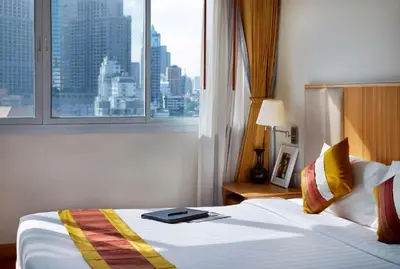 a hotel room with a bed and a window at S.M. GRANDE RESIDENCE in Bangkok