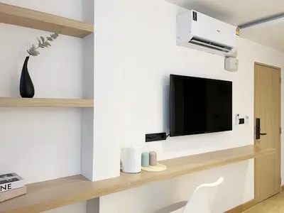 a living room with a tv on a wall at Ascella Bangkok Hotel in Makkasan