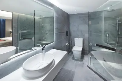 a bathroom with a sink and a toilet and a shower at Grace At Five by Grace Hotel Bangkok in Bangkok
