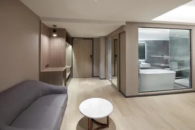 a living room with a couch and a bath tub at Grace At Five by Grace Hotel Bangkok in Bangkok