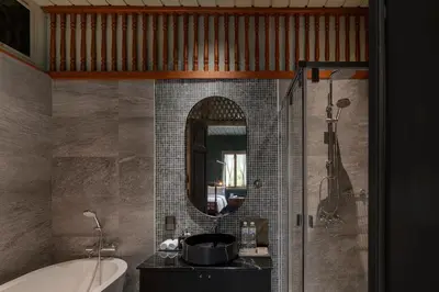 a bathroom with a tub and a sink and a mirror at neil niwas in Bangkok