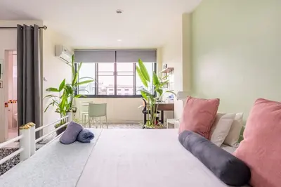 a bedroom with a large bed with pink pillows at CB's - Cheap Boutique Bangkok in Bangkok