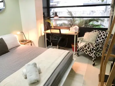 a bedroom with a bed and a desk and a window at CB's - Cheap Boutique Bangkok in Bangkok