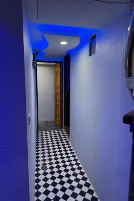 a hallway with a blue ceiling and a checkered floor at Bankhunchang Guest House บ้านขุนช้างห้องพักรายวันรามคำแหง in Ban Zong Katiam