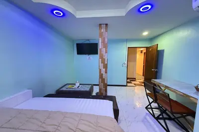 a bedroom with a bed and a table and a room with at Bankhunchang Guest House บ้านขุนช้างห้องพักรายวันรามคำแหง in Ban Zong Katiam