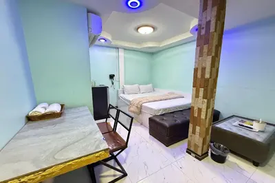 a room with a bed and a table in it at Bankhunchang Guest House บ้านขุนช้างห้องพักรายวันรามคำแหง in Ban Zong Katiam