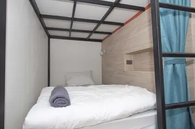 a bed in a room with a ladder at All day hostel at BTS Bang Chak in Bangkok