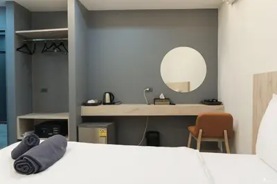 a bedroom with a white bed and a mirror at All day hostel at BTS Bang Chak in Bangkok
