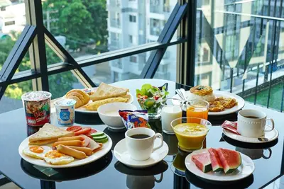 a table topped with plates of breakfast foods and drinks at S3 Siam Bangkok Hotel in Bangkok