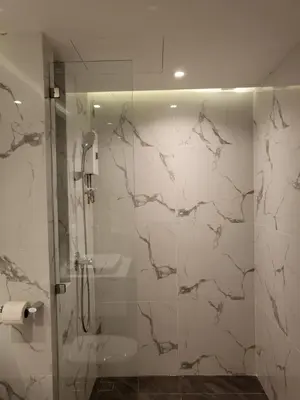 a bathroom with a shower with a glass door at S3 Siam Bangkok Hotel in Bangkok
