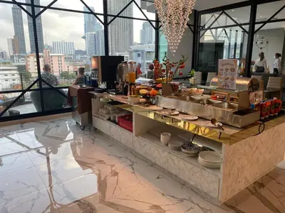 a restaurant with a buffet of food on a counter at S3 Siam Bangkok Hotel in Bangkok