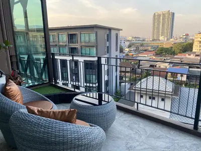 a balcony with chairs and a view of a city at S3 Siam Bangkok Hotel in Bangkok