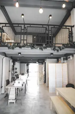 a room with tables and benches and lights at The Cube Hostel Khaosan in Bangkok
