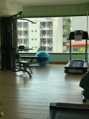 a gym with a chair and a table and a large window at Supalai Oriental Place in Bangkok