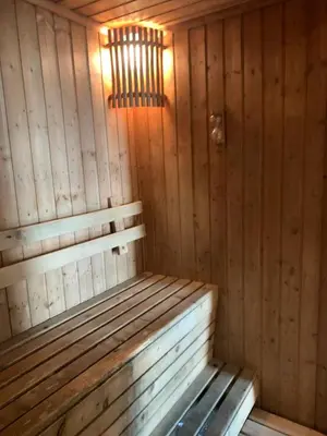 a wooden sauna with a bench in a room at Supalai Oriental Place in Bangkok