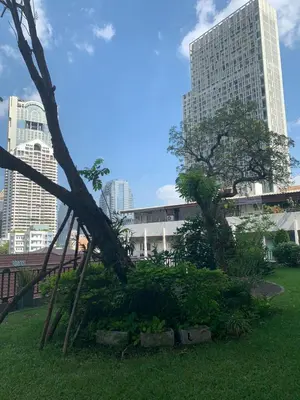 a park in the middle of a city with tall buildings at Supalai Oriental Place in Bangkok