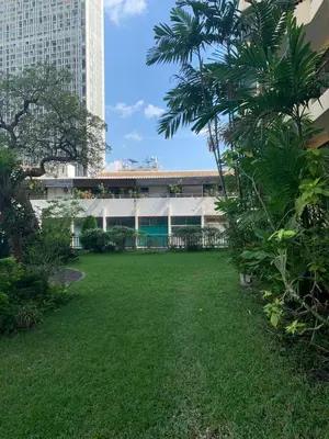 a green yard in front of a building at Supalai Oriental Place in Bangkok