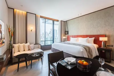 a hotel room with a bed and a table at SILQ Hotel & Residence in Bangkok