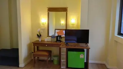 a room with a desk with a television and a mirror at Asia Inn Bangkok 2022 in Bangkok