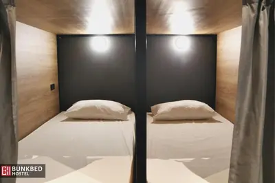 a bed with two white pillows in a room at Bunkbed Hostel in Makkasan