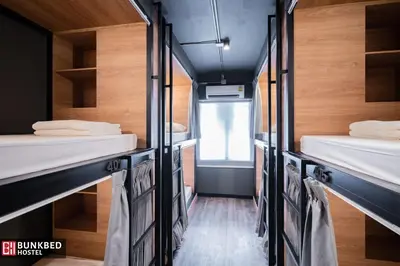 a room with four bunk beds and a window at Bunkbed Hostel in Makkasan