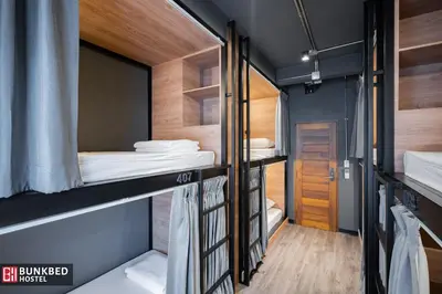a room with three bunk beds and a hallway at Bunkbed Hostel in Makkasan