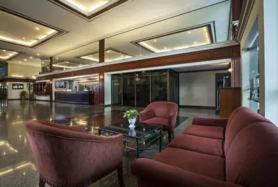 a lobby with chairs and a table in a building at Omni Tower Nana Bangkok - Serviced Apartment on Sukhumvit Soi 4 in Bangkok