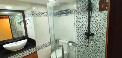 a bathroom with a sink and a mirror and a shower at Omni Tower Nana Bangkok - Serviced Apartment on Sukhumvit Soi 4 in Bangkok