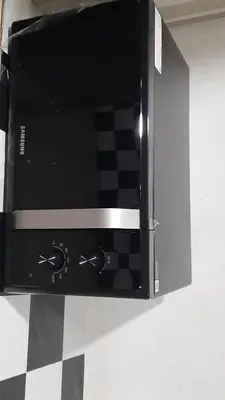 a black microwave oven with a checkered floor at Owl's Nest suk 30 in Bangkok