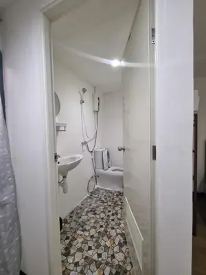 a bathroom with a shower and a sink and a toilet at Owl's Nest suk 30 in Bangkok