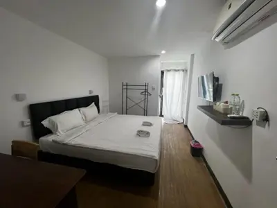 a bedroom with a bed in a white room at Owl's Nest suk 30 in Bangkok