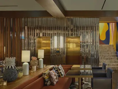 a lobby with a couch and a table and stairs at Public House Bangkok, a Member of Design Hotels in Bangkok