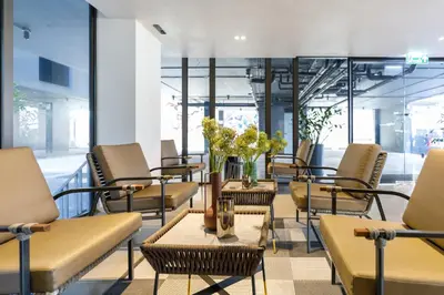 a waiting room with chairs and a table with flowers at Benjarong Hotel Bangkok Ratchada in Bangkok