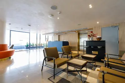 a lobby with chairs and tables in a building at Benjarong Hotel Bangkok Ratchada in Bangkok