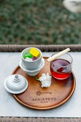 a wooden tray with a bowl of food and a cup of tea at Benjarong Hotel Bangkok Ratchada in Bangkok