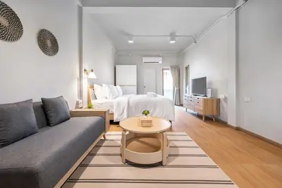 a living room with a couch and a bed at Hotel Wizpark Ratchada in Bangkok