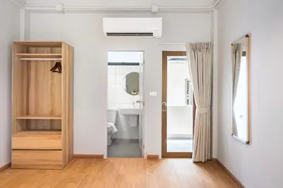a bathroom with a door leading to a sink at Hotel Wizpark Ratchada in Bangkok